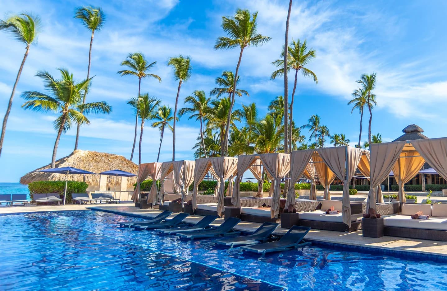 Palm-lined Royalton Punta Cana pool with shaded private cabanas